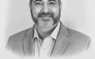 Portrait of Kamyar Shah, business consultant, smiling in a professional suit, representing expertise in operational excellence and consulting services.