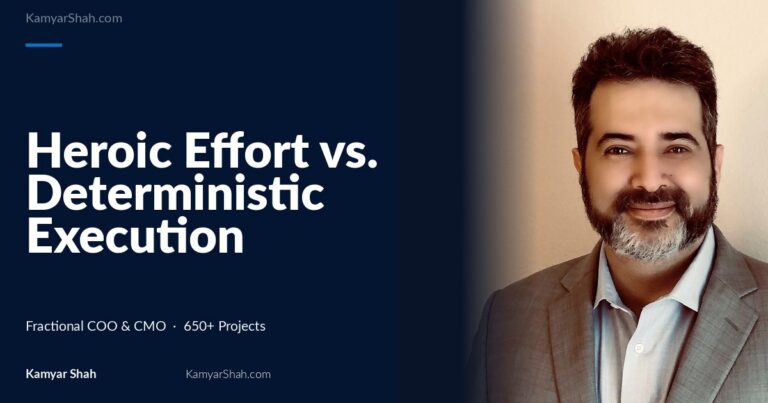 Hero banner: article title 'Heroic Effort vs. Deterministic Execution Systems' on a dark blue panel beside a man in a gray suit smiling on the right.